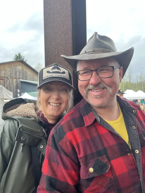 Ett par ler mot kameran på Backwoods 2026, han i cowboyhatt och rutig flanellskjorta