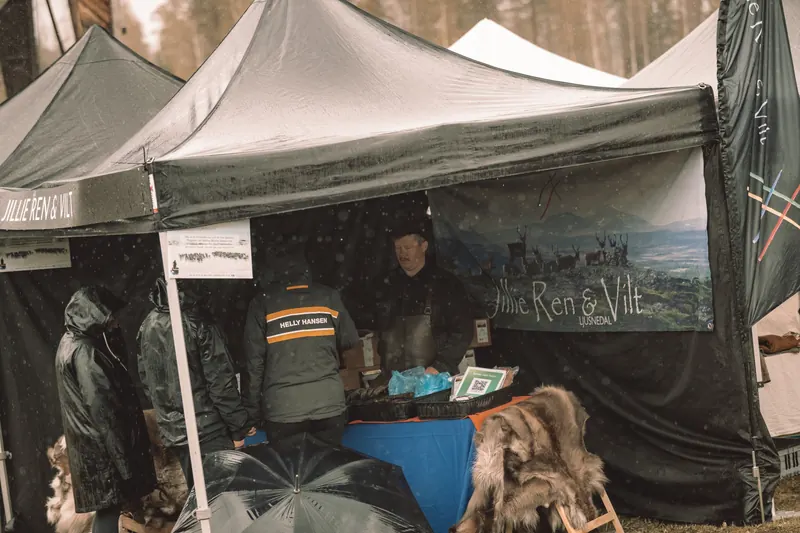 Besökare i regnkläder handlar i tältet hos Jillie Ren & Vilt från Ljusnedal på Backwoods 2026