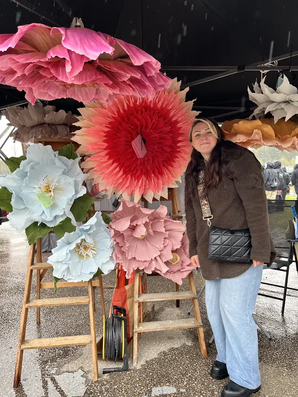 Stora handgjorda pappersblommor på gamla trästegar vid en utställare på Backwoods 2026